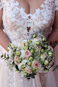 Midsection of bride holding bouquet