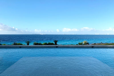 Infinity pool with blue ocean horizon and sky