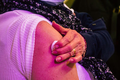 Midsection of woman holding cotton on arm