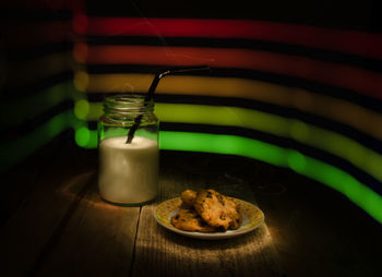 Milk in glass jar with cookies on table