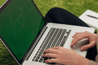 Midsection of woman using laptop on table