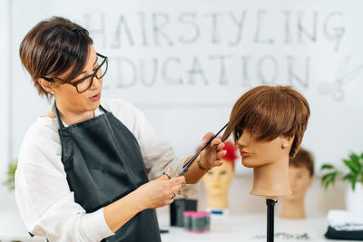 Haircutting education - hairstylist explaining haircutting techniques to students