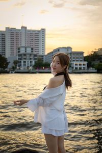 Portrait of young woman standing at beach