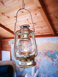 Low angle view of lantern hanging on table at home