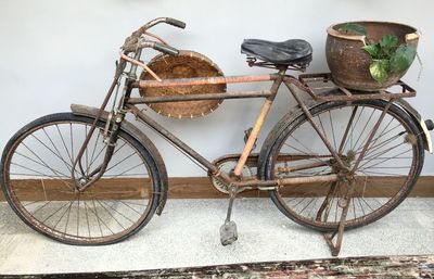 High angle view of rusty bicycle parked against wall