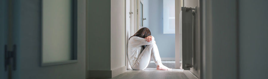 Rear view of woman looking through window