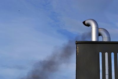 Low angle view of smoke stack against sky