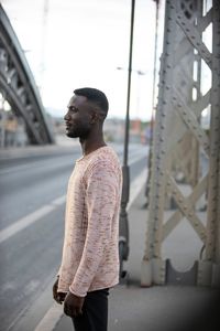 Young man looking away in city