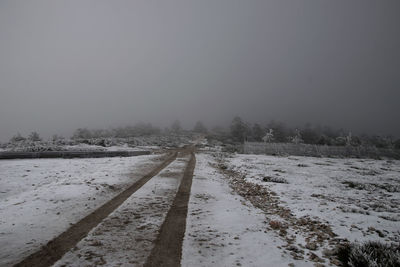 Frozen field against sky during winter
