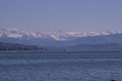 Scenic view of sea and mountains against sky