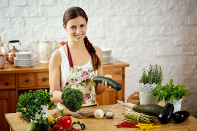 Portrait of woman preparing food on kitchen island at home