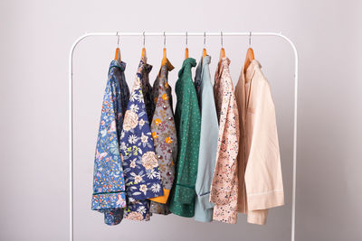 Multi colored clothes hanging on rack against white background
