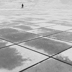 Distant view of woman walking on paved street