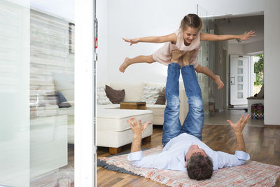 Father balancing his daughter on his feet