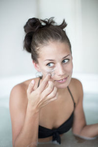 Young woman using face mask