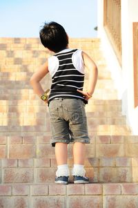 Low angle view of girl with hand on hip