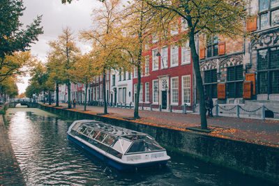 Canal amidst trees and buildings in city