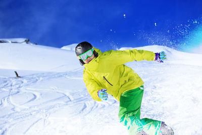 Portrait of young man skiing on snowcapped mountains during winter