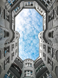 Low angle view of buildings against cloudy sky