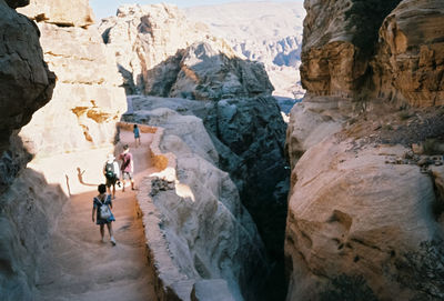 Rear view of people walking on mountain