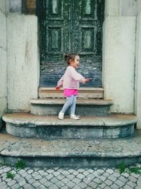 Full length of woman standing against building