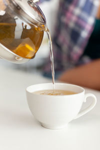 Midsection of woman holding drink on table