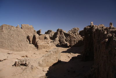 Panoramic view of ancient formations against clear blue sky