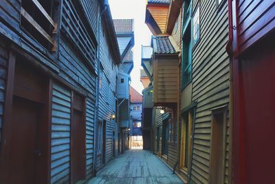 Low angle view of empty alley amidst buildings in city