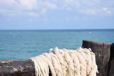 Close-up of wood by sea against sky