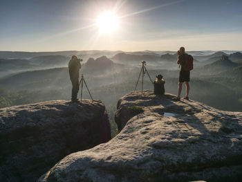 Scenic view of friends photographers taking photo with mountain and more foggy in autumn. 
