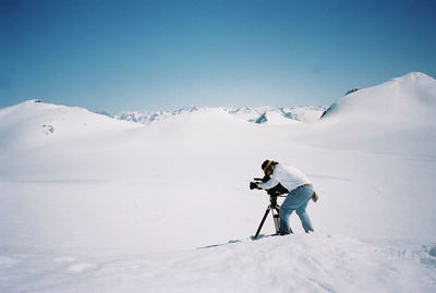 Man skiing on snowcapped mountain against sky