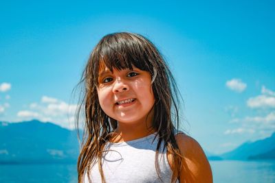 Portrait of smiling woman against blue sky