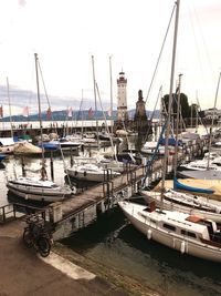 Boats moored at harbor against sky