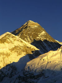 Scenic view of snowcapped mountains against clear blue sky