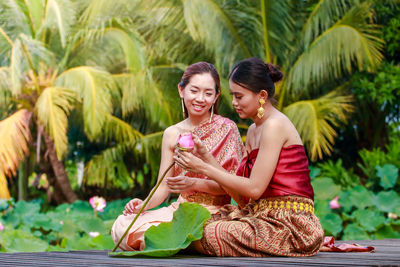 Smiling young woman sitting outdoors