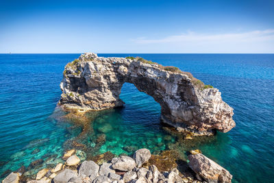 Rock formations in sea against sky