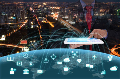 Digital composite image of businessman using digital tablet with cityscape