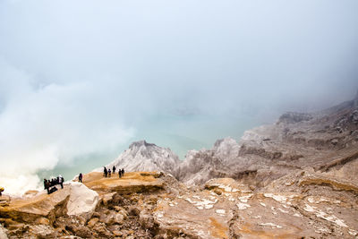 Group of people on mountain against sky