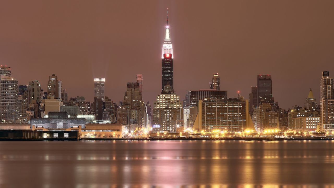 building exterior, illuminated, city, architecture, skyscraper, built structure, night, tower, tall - high, cityscape, modern, water, urban skyline, waterfront, office building, reflection, capital cities, financial district, river, travel destinations