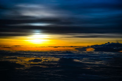 Scenic view of sea against dramatic sky during sunset