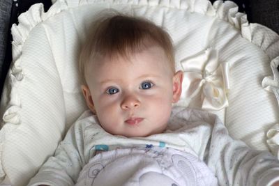 Portrait of cute baby lying on bed