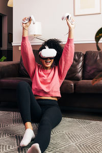 Woman using virtual reality simulator at home