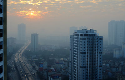 High angle view of buildings in city during sunset