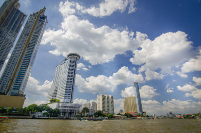 Low angle view of buildings against cloudy sky