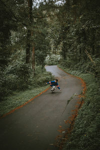 Bicycle on road amidst trees in forest