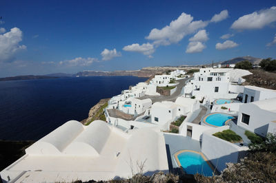 Houses at santorini by aegean sea against sky