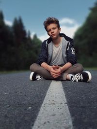 Portrait of man sitting on road