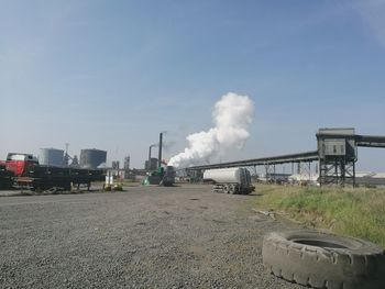 Smoke emitting from factory against sky