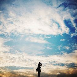 Low angle view of people standing against sky