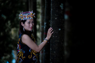 Portrait of young woman standing against wall